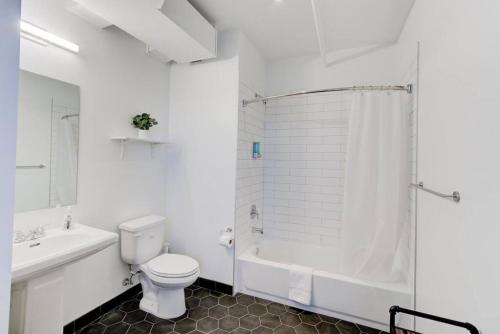 a white bathroom with a toilet and a shower at Revitalized Historic Place in Memphis