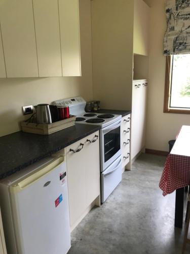 a kitchen with white appliances and a counter top at Pilgrims Rest in Miranda
