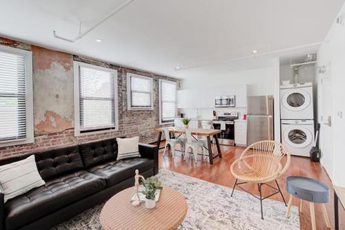 a living room with a black couch and a kitchen at Downtown Loft Style Unit with ALL Modern Amenities in Memphis