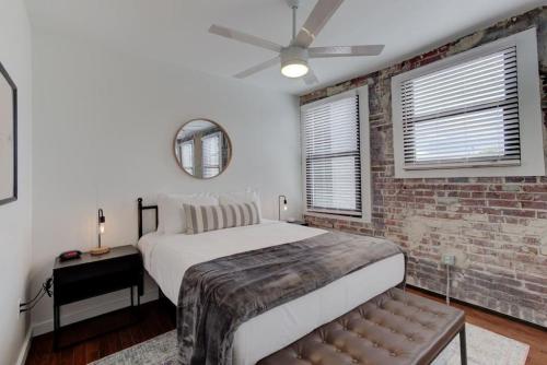 een slaapkamer met een bed en een bakstenen muur bij Handsomely Historic Place in Memphis