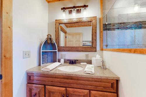 ein Bad mit einem Waschbecken und einem Spiegel in der Unterkunft Lake Therapy Hideaway in New Tazewell