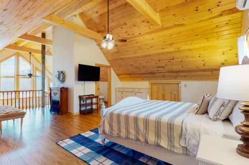 ein Schlafzimmer mit einem Bett und einer Holzdecke in der Unterkunft Lake Therapy Hideaway in New Tazewell