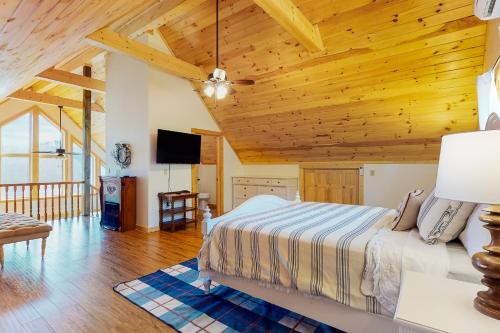 Un dormitorio con una cama y un techo de madera. en Lake Therapy Hideaway, en New Tazewell
