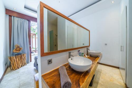 baño con 2 lavabos y espejo grande en Anema Villa Seminyak, en Legian