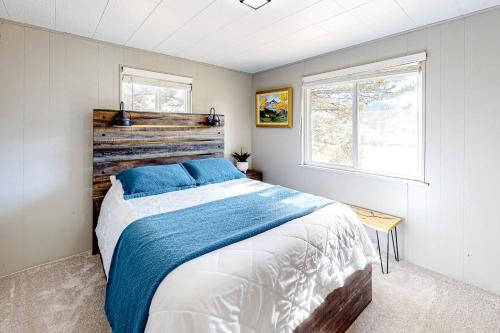a bedroom with a large bed with blue pillows at Fairways & 14ers in Estes Park