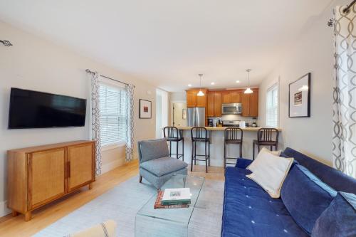 a living room with a blue couch and a kitchen at The Heart of the West End #4 in Portland