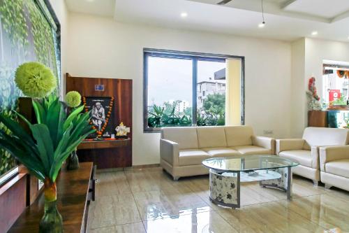 ein Wohnzimmer mit einem Sofa und einem Tisch in der Unterkunft Super Capital O Hotel C Tara in Shirdi