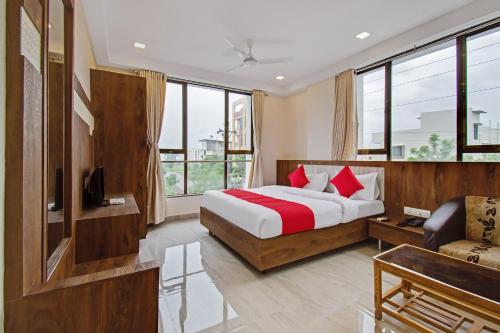 Habitación de hotel con cama, sofá y ventanas en Super Capital O Hotel C Tara en Shirdi