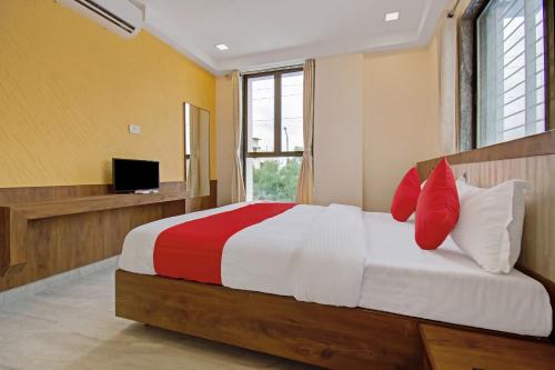 una camera da letto con un letto con cuscini rossi e bianchi di Super Capital O Hotel C Tara a Shirdi