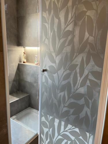 una ducha con una pared estampada de color gris y blanco en CaSa GrinGa "Moderna casa entre el Campo y la Ciudad" en Pergamino