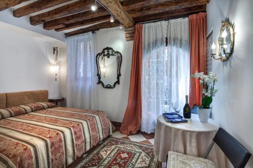 1 dormitorio con cama, mesa y ventana en Nice Venice Apartments in San Marco en Venecia