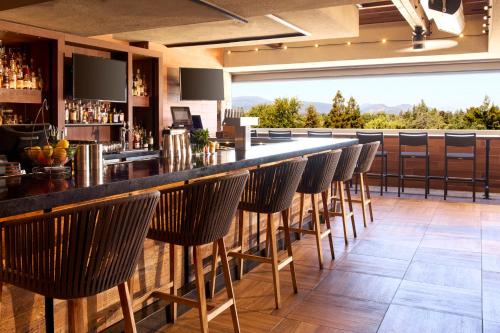 a bar with chairs at a restaurant with a view at Archer Hotel Napa in Napa