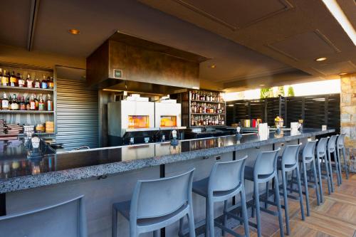 a bar with a row of chairs at a restaurant at Archer Hotel Napa in Napa