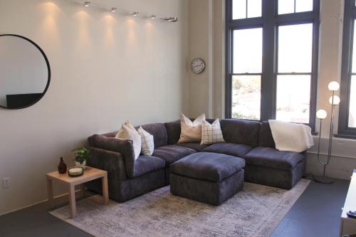 een woonkamer met een blauwe bank en een tafel bij NEW! Lavish Studio Loft in Central Downtown SLC in Salt Lake City