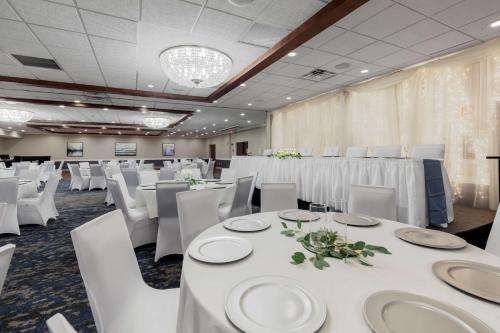 a banquet hall with white tables and white chairs at Best Western Plus Dubuque Hotel and Conference Center in Dubuque