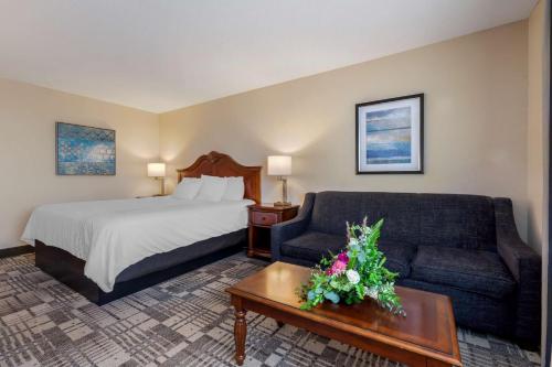 a hotel room with a bed and a couch at Best Western Plus Dubuque Hotel and Conference Center in Dubuque