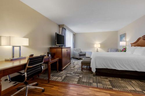 a hotel room with a bed and a desk and a computer at Best Western Plus Dubuque Hotel and Conference Center in Dubuque