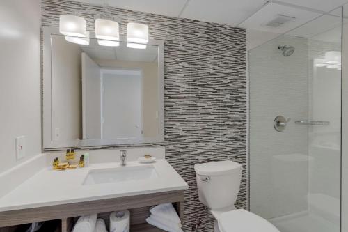 a bathroom with a sink and a toilet and a shower at Best Western Plus Brooklyn Bay Hotel in Brooklyn