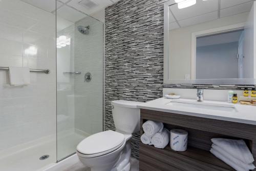 a bathroom with a toilet and a sink and a shower at Best Western Plus Brooklyn Bay Hotel in Brooklyn