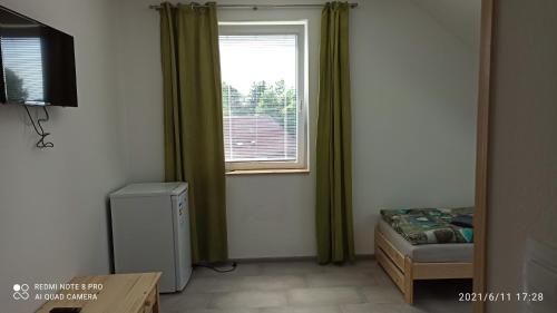 een kamer met een raam, een bed en een radiator bij Penzion Forest 2 in Rozvadov