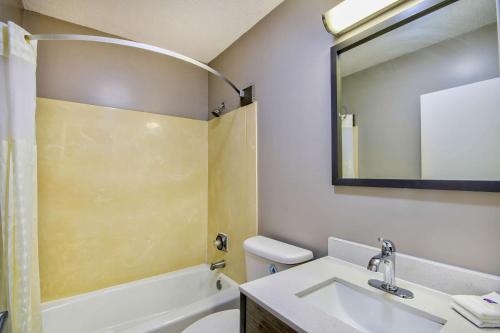 a bathroom with a sink and a toilet and a mirror at Motel 6 Jeffersonville, IN in Jeffersonville