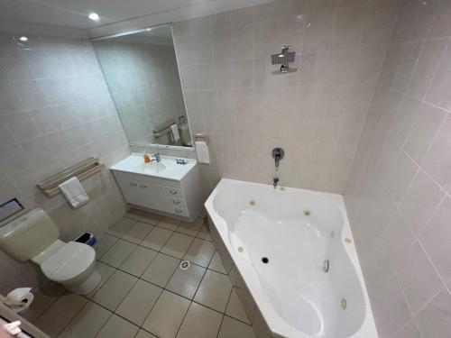 a white bathroom with a tub and a toilet at Selmar Place in Windermere