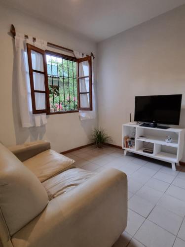 un soggiorno con divano e TV a schermo piatto di Departamento en complejo residencial a Mendoza