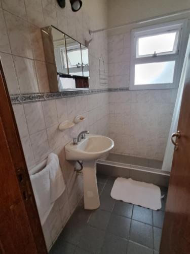 y baño con lavabo y espejo. en Departamento en complejo residencial en Mendoza