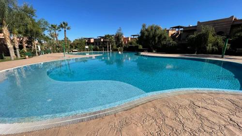 a large swimming pool with blue water at Atlas Golf Resort Marrakech in Marrakech