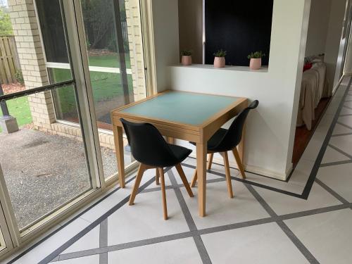 a table and two chairs sitting next to a window at Shared house with other guests near shopping center and theme parks in Gold Coast