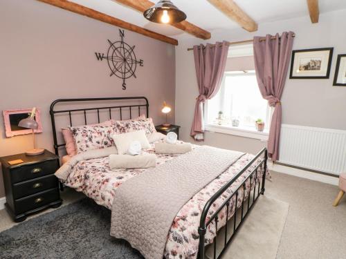 a bedroom with a bed and a window at Pepper Cottage in Bishop Auckland