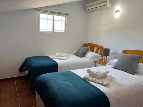 a room with two beds with towels on them at Villa Amaris a una hora de madrid in Santa Maria del Tietar