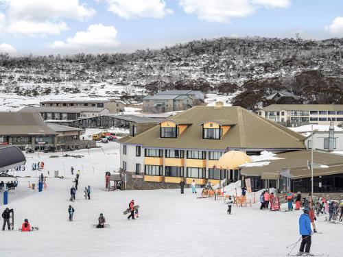 a group of people in the snow in front of a building at Perisher Manor Hotel in Perisher Valley