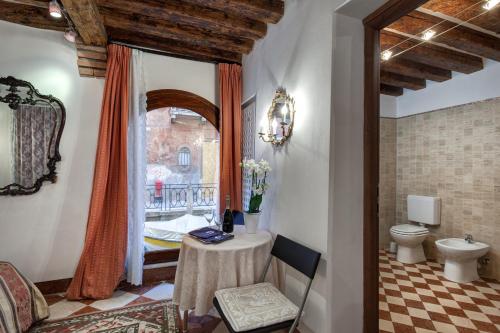 een badkamer met een tafel, een toilet en een raam bij Nice Venice Apartments in San Marco in Venetië