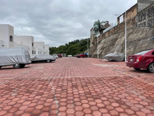 un aparcamiento de ladrillo con coches estacionados al lado de los edificios en Casa en Tequesquitengo con acceso al lago, en Jojutla de Juárez