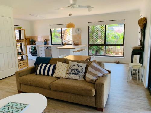 a living room with a couch and a kitchen at 18 Knudsen Street in Elliott Heads