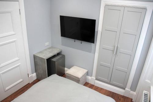 a bedroom with a bed and a flat screen tv on the wall at Laurieston Inn in Falkirk