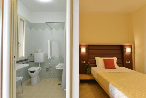 a bedroom with a bed and a bathroom with a tub at Hotel Rosignano in Rosignano Solvay