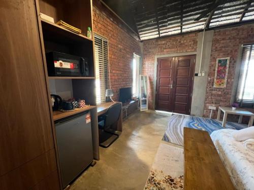 a room with a bed and a desk in a room at Rembulan Escape - The Red Bowl in Kampung Penarik