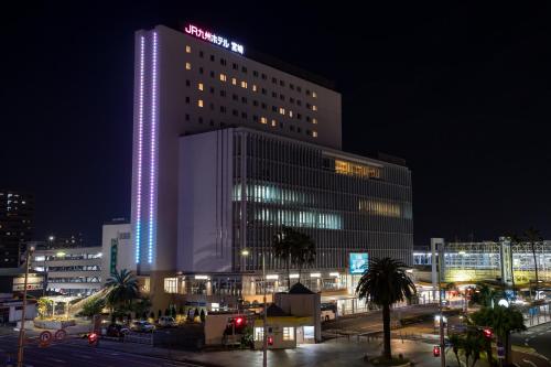 a building with a lit up sign on it at night at JR Kyushu Hotel Miyazaki in Miyazaki