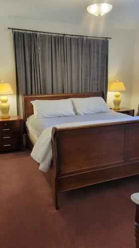a large bed in a bedroom with two lamps at The Elizabeth Inn and Restaurant in Bethel