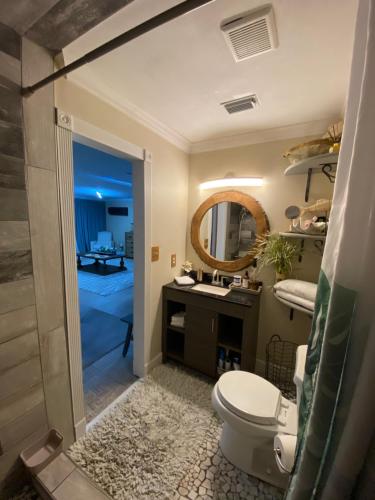 a bathroom with a toilet and a sink and a mirror at Hermosa Flor apartment( Duplex). in Pensacola