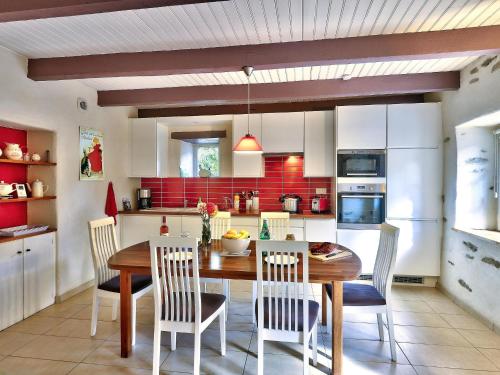 uma cozinha com uma mesa de jantar em madeira e cadeiras em Charming holiday home with garden em Huelgoat