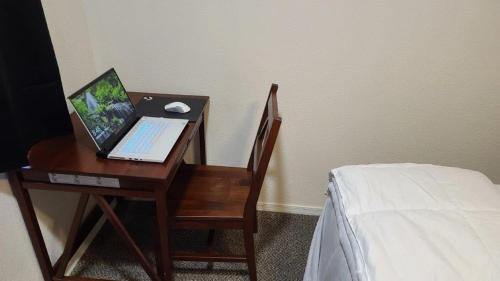 a desk with a laptop computer on a chair next to a bed at 070A Grand Canyon Studio with Kitchenette, Accommodates 4 in Valle