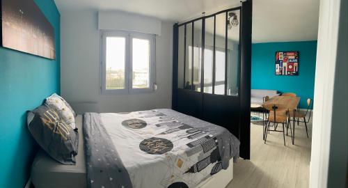 een slaapkamer met een bed en een eetkamer bij Grand Studio Lumineux Caen Memorial in Caen
