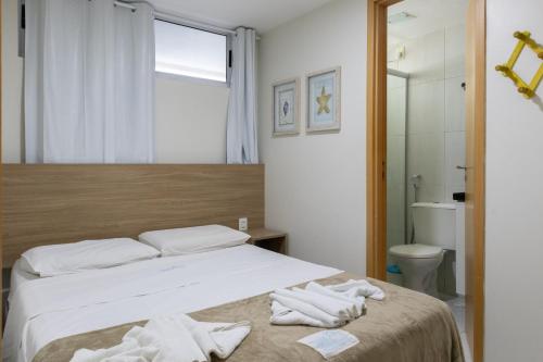 a bedroom with a bed with towels on it at Ocean Residence in Porto De Galinhas