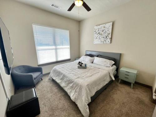 a bedroom with a bed and a blue chair at Luxury Suite in the heart of Dallas, a Home away from Home! in Richardson