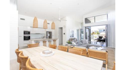 a kitchen and living room with a wooden table and chairs at Fennes On Banzai in Kingscliff