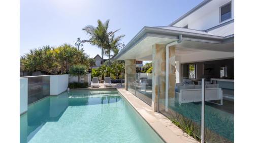 an image of a swimming pool next to a house at On Northpoint at Salt in Kingscliff