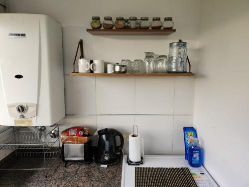cocina con paredes blancas y encimera con electrodomésticos en departamento temporal La Cañada en Córdoba